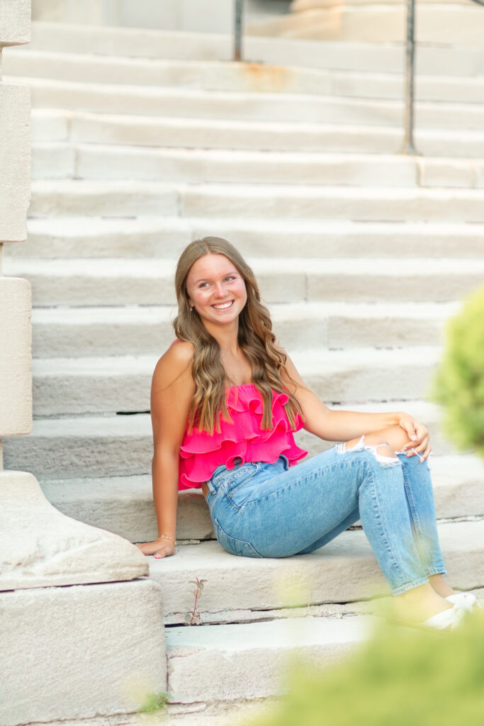 senior girl by a building in downtown port huron for her senior photos